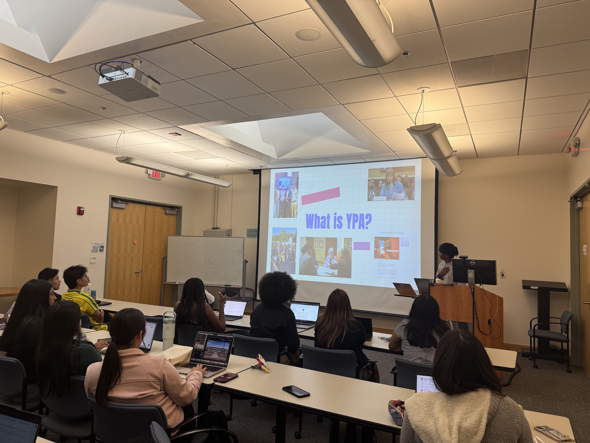 Student giving a presentation titled "What is YPA?" to a classroom of other students